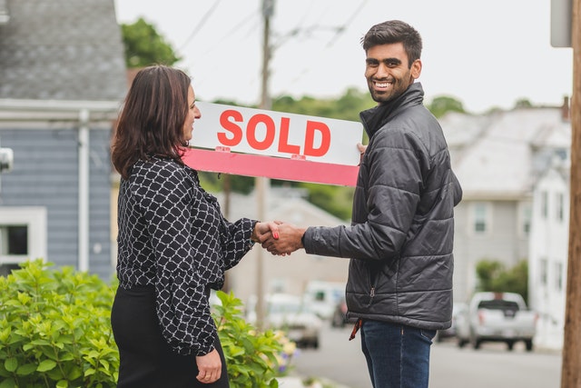 man shaking hands with woman after selling a home